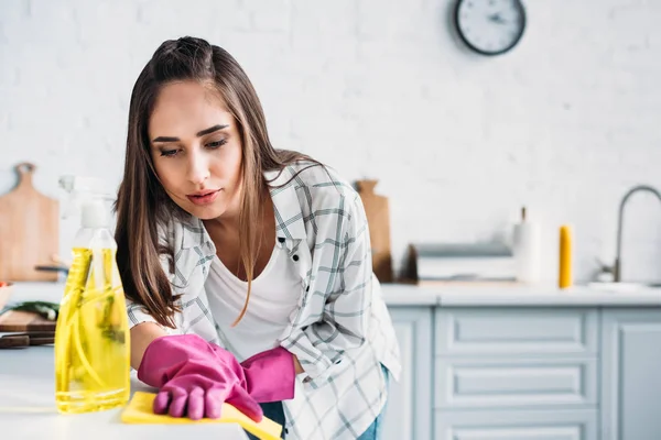 Chica limpieza cocina contador con trapo en casa - foto de stock