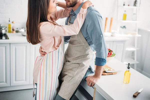 Couple cuddling and leaning on kitchen counter in kitchen — Stock Photo