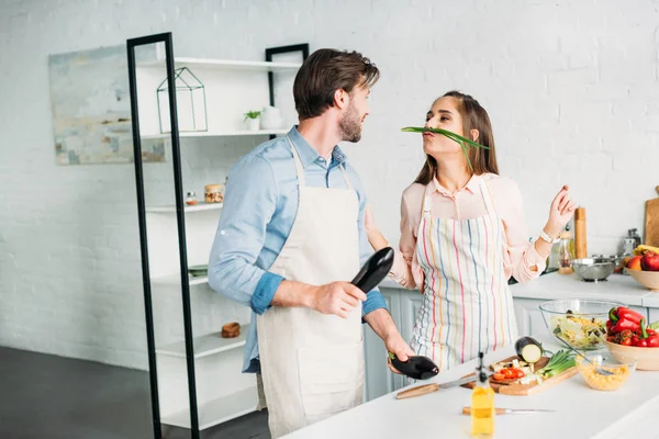 Pareja de muecas con verduras mientras cocina en la cocina - foto de stock