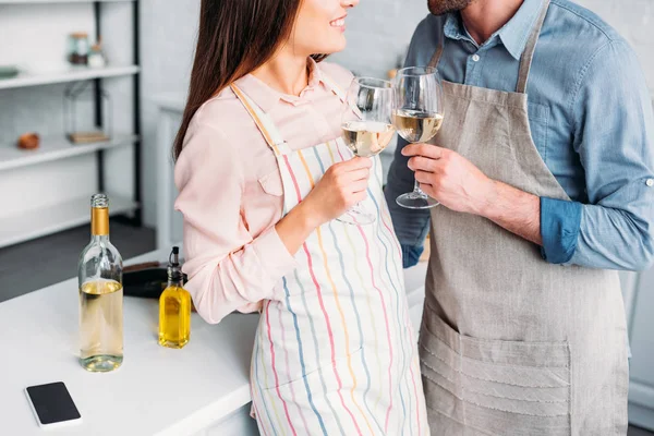 Image recadrée de couple cliquetis avec verres à vin dans la cuisine — Photo de stock