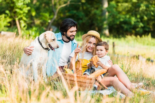 Madre señalando algo a su hijo en el picnic - foto de stock