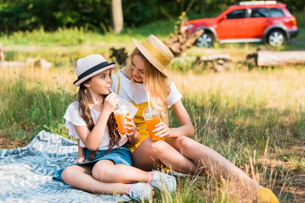 Mutter und Tochter trinken Saft beim Picknick — Stockfoto