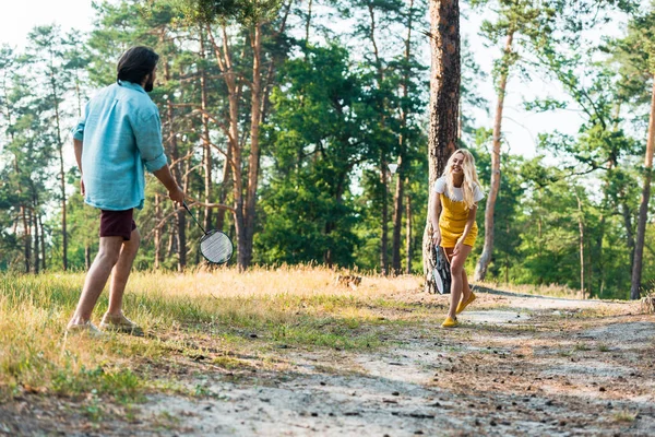 Happy couple playing badminton outdoors — Stock Photo