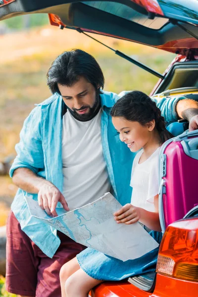 Père et fille regardant la carte au coffre de la voiture — Photo de stock