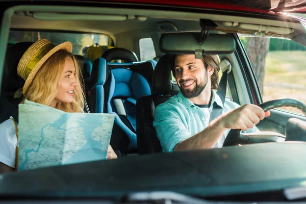 Couple heureux voyageant en voiture avec la carte — Photo de stock