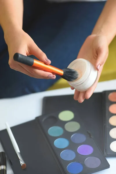 Cropped shot of woman holding face powder and makeup brush in hands at home — Stock Photo