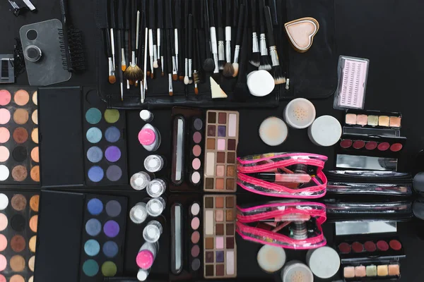 Top view of arranged various makeup equipment on black tabletop — Stock Photo