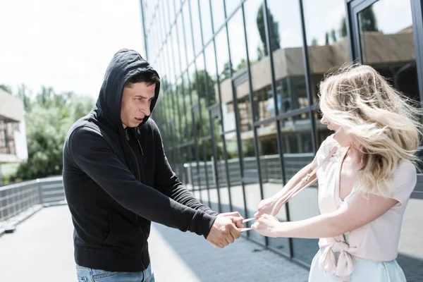 Male criminal robber stealing womans bag on street — Stock Photo