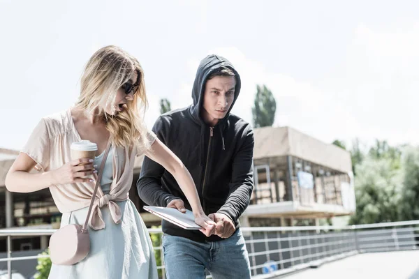 Male robbery stealing laptop from hands of scared woman with coffee to go — Stock Photo