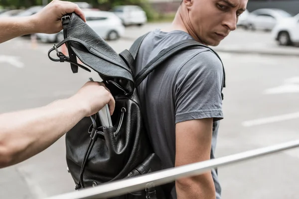 Robbery pickpocketing laptop from mans backpack on street — Stock Photo