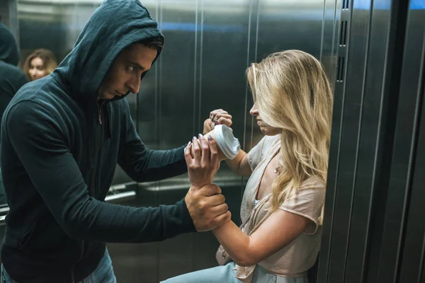 Aggressive robber attacking woman in elevator — Stock Photo