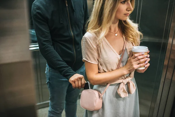 Robbery pickpocketing smartphone from womans bag in elevator — Stock Photo