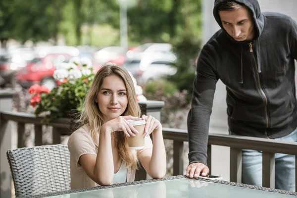 Furto di smartphone da tavolo sulla terrazza del ristorante mentre la donna distoglie lo sguardo — Foto stock