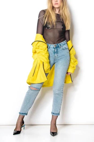 Cropped shot of young woman in transparent shirt and yellow jacket on white — Stock Photo