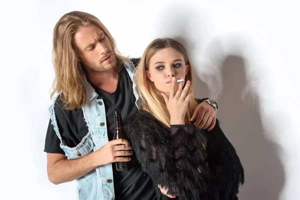 Young man with bottle of beer talking to girlfriend while she smoking on white — Stock Photo