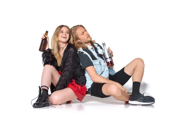 Young drunk couple with rum and beer sitting on floor on white — Stock Photo