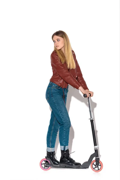 Attractive young woman in leather jacket with scooter on white — Stock Photo