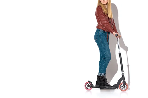 Tiro recortado de mujer joven con estilo en chaqueta de cuero con scooter en blanco - foto de stock