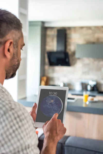 Selective focus of man using digital tablet in hands in kitchen — Stock Photo