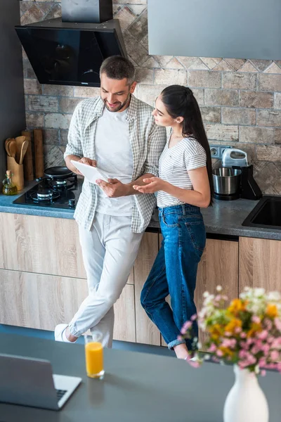 Married couple using digital tablet together in kitchen, smart home concept — Stock Photo