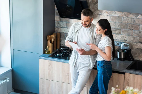 Married couple using digital tablet together in kitchen, smart home concept — Stock Photo