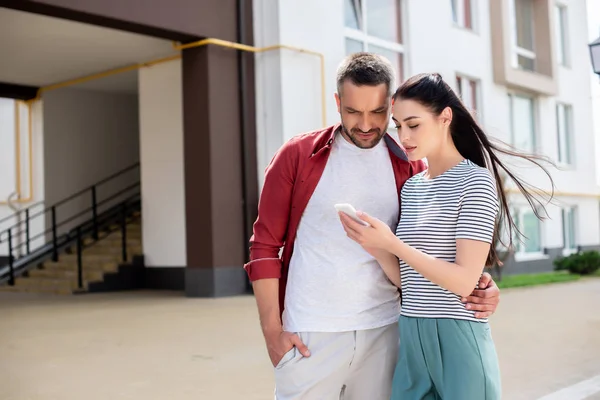 Retrato de casal usando smartphone na rua — Fotografia de Stock