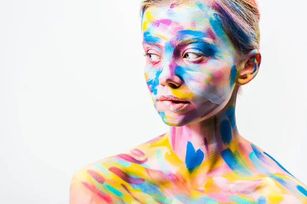 Chica atractiva con colorido arte del cuerpo brillante mirando hacia otro lado aislado en blanco - foto de stock