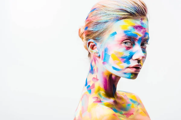 Приваблива дівчина з барвистим яскравим мистецтвом тіла дивиться на камеру ізольовано на білому — стокове фото