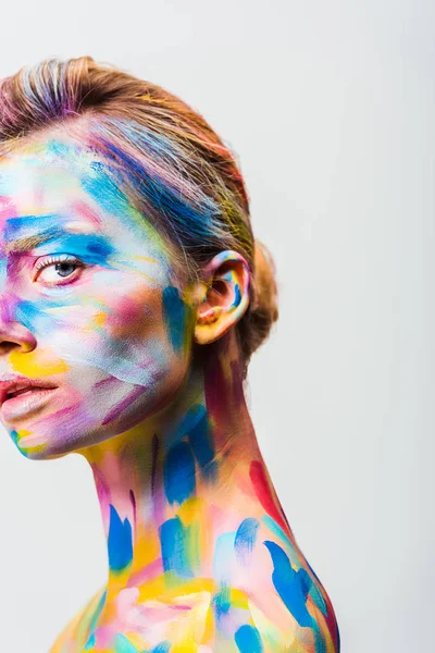 Imagem cortada de menina atraente com arte corporal brilhante colorido olhando para a câmera isolada no branco — Fotografia de Stock