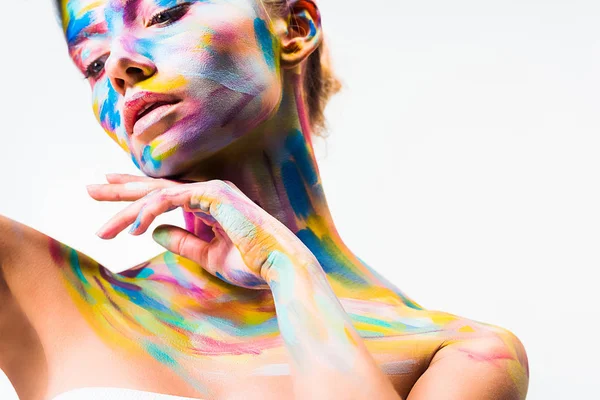 Atractiva chica con colorido brillante cuerpo arte tocando cuello aislado en blanco - foto de stock