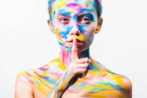 Menina atraente com arte corporal brilhante colorido mostrando gesto de silêncio isolado no branco — Fotografia de Stock