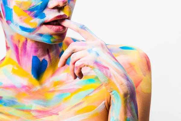 Immagine ritagliata di ragazza con colorata arte del corpo luminoso mordere dito isolato su bianco — Foto stock