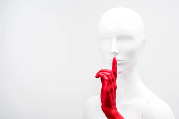 Cropped image of woman in red paint showing silence gesture with mannequin isolated on white — Stock Photo