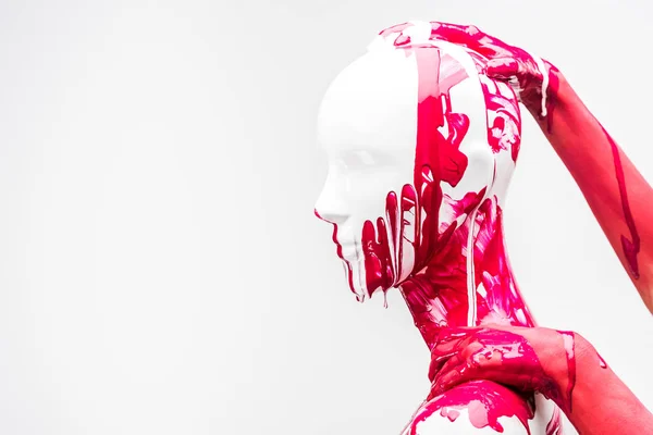 Abgeschnittenes Bild eines Mädchens in roter Farbe, das Schaufensterpuppe an Kopf und Schulter berührt, isoliert auf Weiß — Stockfoto