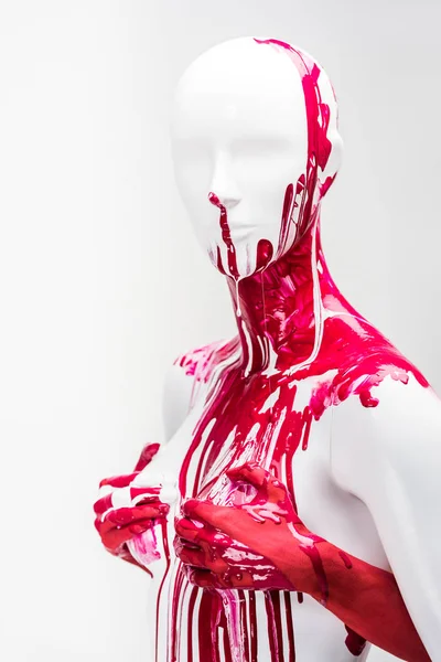 Imagen recortada de niña en pintura roja tocando pechos maniquí aislado en blanco - foto de stock