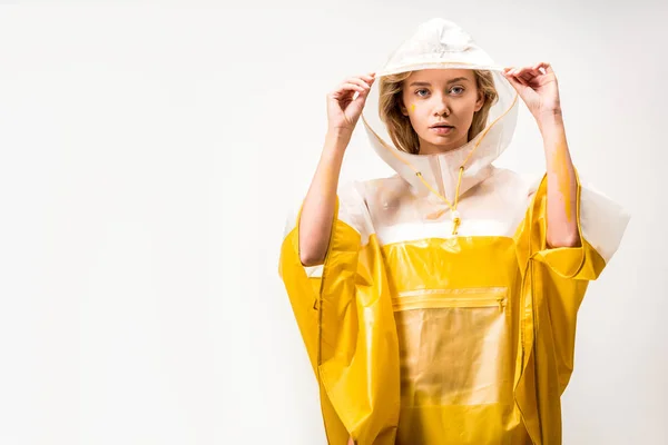 Belle femme en imperméable tenant capuche et regardant la caméra isolée sur blanc — Photo de stock