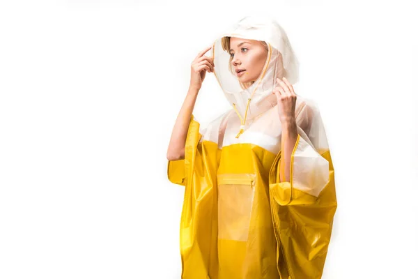 Bela mulher em capa de chuva segurando capuz e olhando para longe isolado no branco — Fotografia de Stock