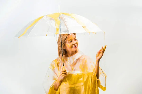 Femme debout sous le parapluie et touchant goutte à goutte peintures isolées sur blanc — Photo de stock
