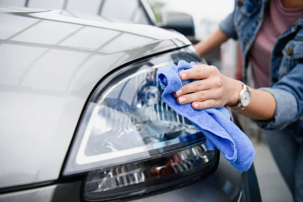 Immagine ritagliata di donna che pulisce auto all'atto di autolavaggio con straccio — Foto stock