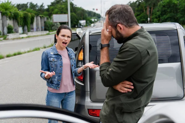 Irritated woman screaming on driver on road after car accident — Stock Photo