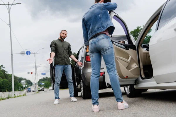 Vista ad angolo basso dei conducenti in piedi vicino alle auto su strada dopo incidente stradale — Foto stock