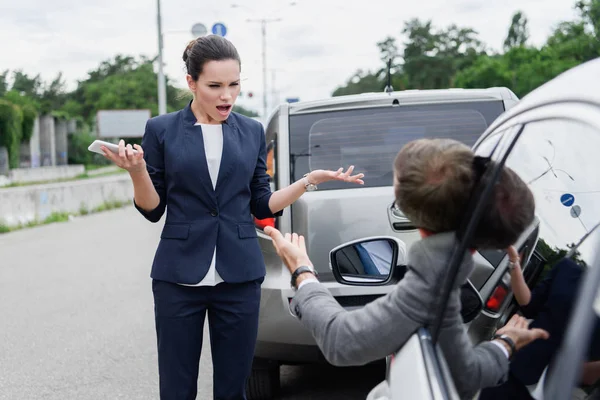 Des gens d'affaires crient sur la route après un accident de voiture — Photo de stock