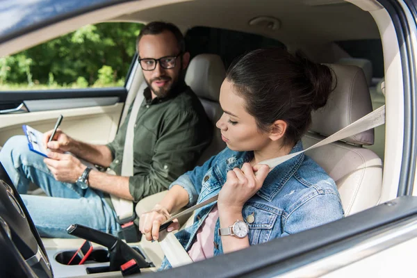 Student fastening seat belt in car during driving test — Stock Photo