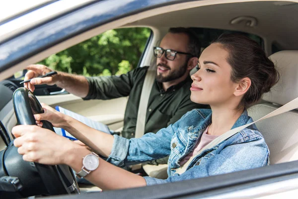 Estudiante alegre y profesor en coche en el examen de conducir — Stock Photo