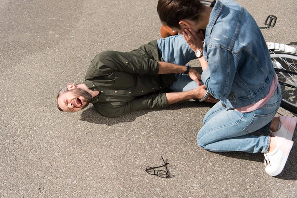 Driver looking at screaming biker after car accident on road — Stock Photo