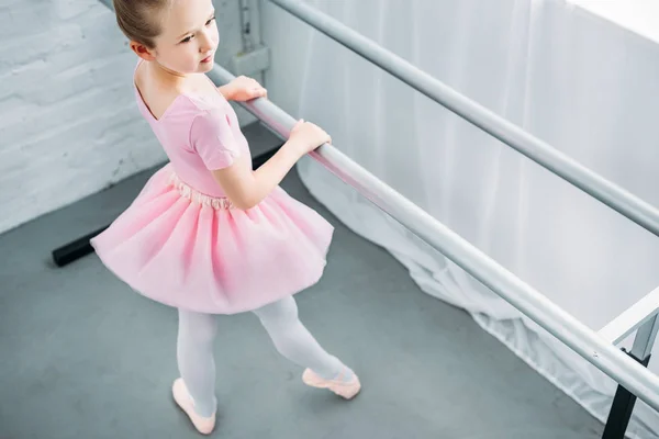 Visão de alto ângulo da pequena bailarina graciosa que se exercita na escola de balé — Fotografia de Stock