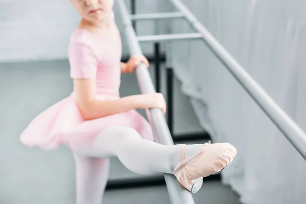 Селективное внимание ребенка в розовой пачке, занимающегося в балетной школе — стоковое фото