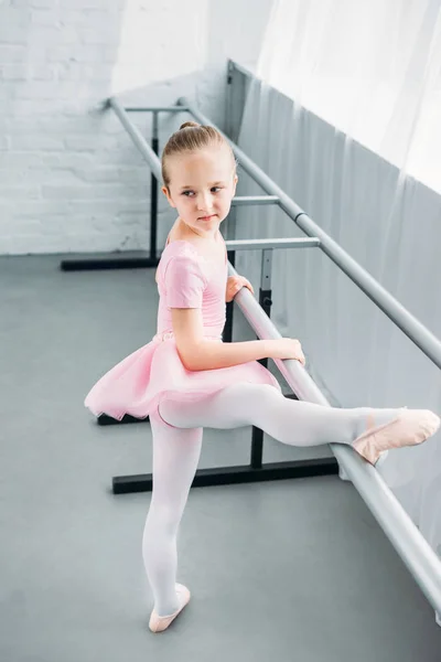 Visão de alto ângulo da criança em tutu rosa exercitando-se na escola de balé — Fotografia de Stock