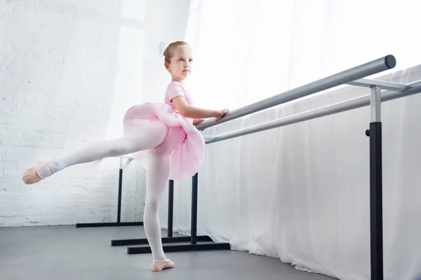 Adorable little ballerina in pink tutu practicing in ballet studio — Stock Photo