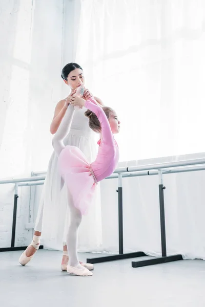 Giovane formazione di ballerina con bambino in tutù rosa in studio di danza classica — Foto stock